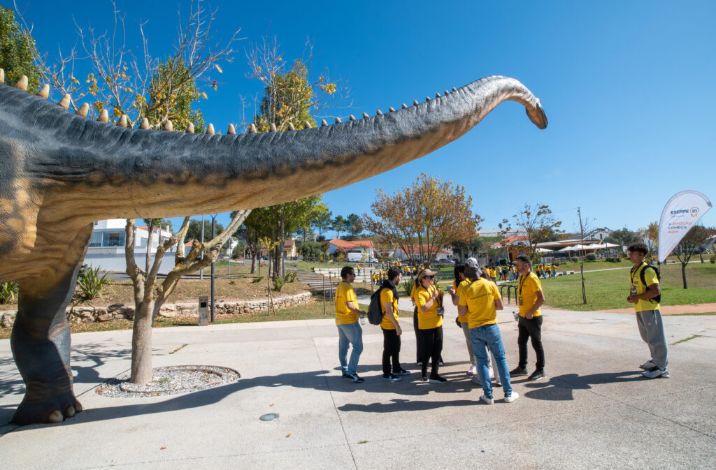 fotografia de grupo em jardim com estátua de dinossauro